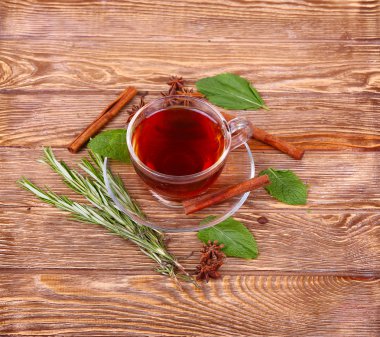 Cam bardak yeşil çay tarçın ile bir ahşap masa arka plan üzerinde sopa.