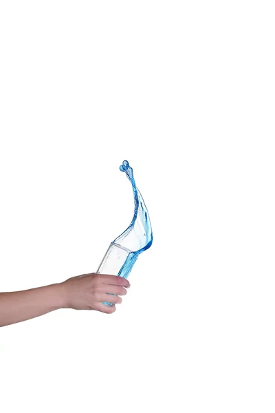 Éclaboussures d'eau bleue dans le verre tenu à la main, fond blanc — Photo