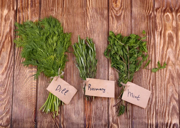 Fresh herbs hanging over wooden background — Stock Photo, Image