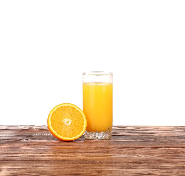 Vaso de zumo de naranja recién prensado con mitad de naranja en rodajas sobre mesa de madera —  Fotos de Stock