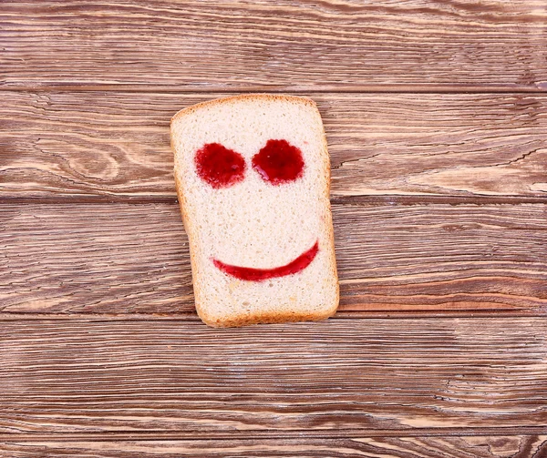 Cara sonriente feliz hecha de ketchup en una rebanada de pan — Foto de Stock
