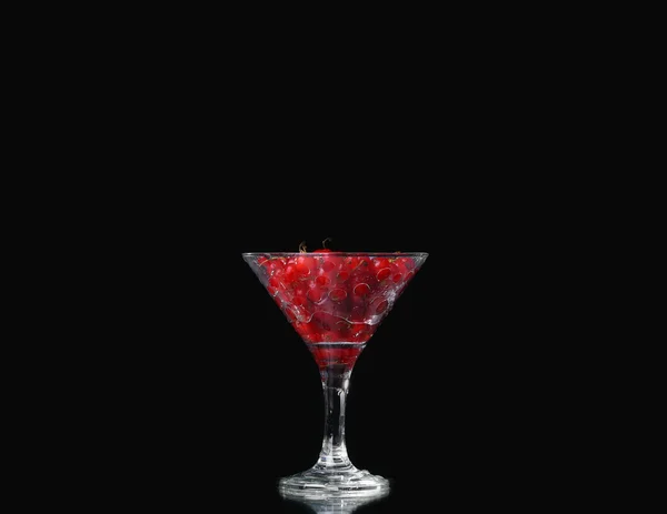 Wasser mit roten Johannisbeeren auf schwarzem Hintergrund — Stockfoto