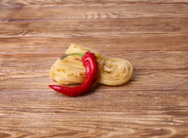 Makarna makarna erişte ahşap bir masa üzerinde pul biber ile