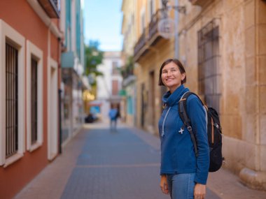 İspanya 'nın Alicante eyaletinin büyüleyici dar sokaklarında gezinen, tarihi Akdeniz mimarisi ile çevrili, barışçıl atmosfer ve kültürel ortamın tadını çıkaran genç bir kadın..