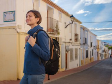 İspanya 'nın Alicante eyaletinin büyüleyici dar sokaklarında gezinen, tarihi Akdeniz mimarisi ile çevrili, barışçıl atmosfer ve kültürel ortamın tadını çıkaran genç bir kadın..
