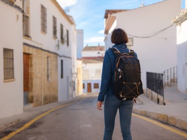 İspanya 'nın Alicante eyaletinin büyüleyici dar sokaklarında gezinen, tarihi Akdeniz mimarisi ile çevrili, barışçıl atmosfer ve kültürel ortamın tadını çıkaran genç bir kadın..