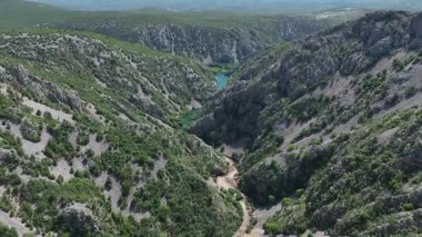Krnjeza ve Krupa nehirlerinin birleştiği hava manzarası. Dolambaçlı Zrmanja nehrinin havadan çekimleri derin kanyonu, bereketli bahar renklerini ve uzak yolları kesiyor.