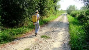 Kırsal alanlarda yürüyüş yapan bir kadın, açık araziler, temiz hava ve huzurlu kırsal manzarayla çevrili. Açık havanın doğal güzelliğini ve sükunetini seviyor..