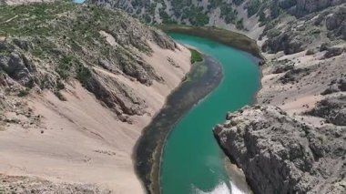 Obrovac 'tan nehir ağzı antenine kadar Zrmanja kanyonu nehri. Dolambaçlı Zrmanja nehrinin havadan çekimleri derin kanyonu, bereketli bahar renklerini ve uzak yolları kesiyor.