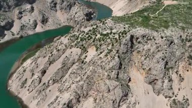 Obrovac 'tan nehir ağzı antenine kadar Zrmanja kanyonu nehri. Dolambaçlı Zrmanja nehrinin havadan çekimleri derin kanyonu, bereketli bahar renklerini ve uzak yolları kesiyor.