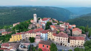 Yaz boyunca Hırvatistan 'ın Istria kentindeki Oprtalj tepesindeki ortaçağ kasabasının hava aracı görüntüleri. Tarihi taş evler, dar sokaklar, çevre tepeler ve otantik Avrupa manzarası.