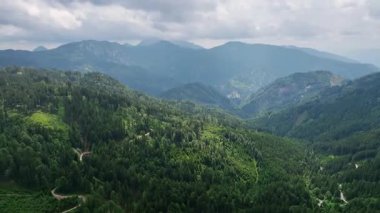 Slovenya Alpleri 'nin sinematik hava aracı görüntüleri. Orman bulutlu bir yaz günü yeşil dağ ağaçlarını, huzurlu atmosferi, doğal manzarayı ve sakin dağ manzarasını gösterir.