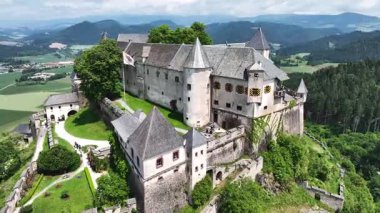 Tepedeki Hochosterwitz Kalesi 'ni, güçlendirilmiş duvarları, dramatik uçurumları, yaz renklerini, silip süpüren hava hareketlerini, tarihi dönüm noktalarını görüntüleyen sinematik dron görüntüleri.