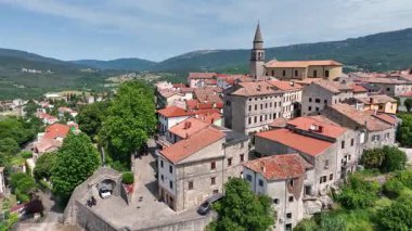 Yaz başında Hırvatistan 'ın Istria kentindeki Buzet tarihi ortaçağ kasabasının insansız hava aracı görüntüsü, eski taş binalar, tepe yerleşimi, çevre ormanları ve yeşil vadi manzarasını gösteriyor