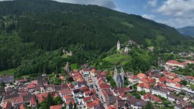 Yaz insansız hava aracı görüntüleri ortaçağ Friesach 'ını gösteriyor, eski güçlendirilmiş duvarlar, çatılar, kuleler, tepeler, sakin atmosfer, sıcak gün ışığı, hafif sinematik hareket