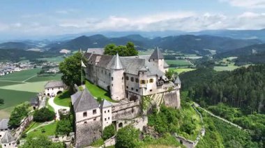 Tepedeki Hochosterwitz Kalesi 'ni, güçlendirilmiş duvarları, dramatik uçurumları, yaz renklerini, silip süpüren hava hareketlerini, tarihi dönüm noktalarını görüntüleyen sinematik dron görüntüleri.