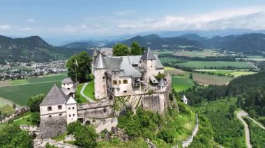 Tepedeki Hochosterwitz Kalesi 'ni, güçlendirilmiş duvarları, dramatik uçurumları, yaz renklerini, silip süpüren hava hareketlerini, tarihi dönüm noktalarını görüntüleyen sinematik dron görüntüleri.
