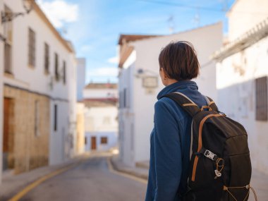 İspanya 'nın Alicante eyaletinin büyüleyici dar sokaklarında gezinen, tarihi Akdeniz mimarisi ile çevrili, barışçıl atmosfer ve kültürel ortamın tadını çıkaran genç bir kadın..