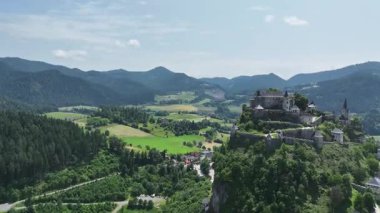 Tepedeki Hochosterwitz Kalesi 'ni, güçlendirilmiş duvarları, dramatik uçurumları, yaz renklerini, silip süpüren hava hareketlerini, tarihi dönüm noktalarını görüntüleyen sinematik dron görüntüleri.