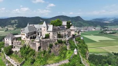 Tepedeki Hochosterwitz Kalesi 'ni, güçlendirilmiş duvarları, dramatik uçurumları, yaz renklerini, silip süpüren hava hareketlerini, tarihi dönüm noktalarını görüntüleyen sinematik dron görüntüleri.