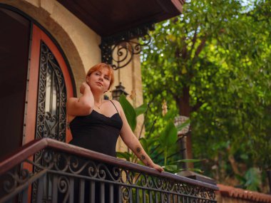 Zarif siyah elbiseli genç bir kadın yaz günü Türkiye 'nin Keleci, Antalya kentinde yürüyor. Kadın gezgin ilginç yerler ve popüler yerler keşfediyor.