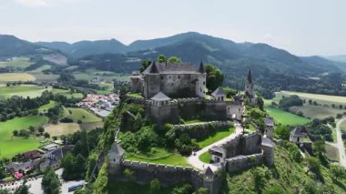 Tepedeki Hochosterwitz Kalesi 'ni, güçlendirilmiş duvarları, dramatik uçurumları, yaz renklerini, silip süpüren hava hareketlerini, tarihi dönüm noktalarını görüntüleyen sinematik dron görüntüleri.