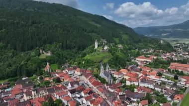 Yaz insansız hava aracı görüntüleri ortaçağ Friesach 'ını gösteriyor, eski güçlendirilmiş duvarlar, çatılar, kuleler, tepeler, sakin atmosfer, sıcak gün ışığı, hafif sinematik hareket