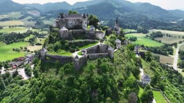 Tepedeki Hochosterwitz Kalesi 'ni, güçlendirilmiş duvarları, dramatik uçurumları, yaz renklerini, silip süpüren hava hareketlerini, tarihi dönüm noktalarını görüntüleyen sinematik dron görüntüleri.