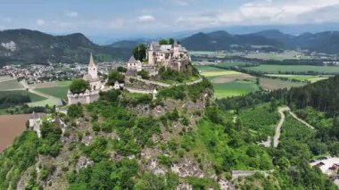 Tepedeki Hochosterwitz Kalesi 'ni, güçlendirilmiş duvarları, dramatik uçurumları, yaz renklerini, silip süpüren hava hareketlerini, tarihi dönüm noktalarını görüntüleyen sinematik dron görüntüleri.