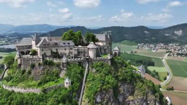 Tepedeki Hochosterwitz Kalesi 'ni, güçlendirilmiş duvarları, dramatik uçurumları, yaz renklerini, silip süpüren hava hareketlerini, tarihi dönüm noktalarını görüntüleyen sinematik dron görüntüleri.