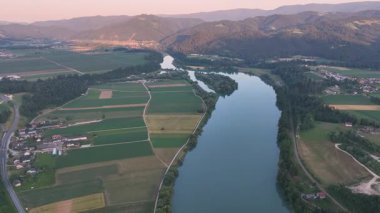 Drava Nehri 'nin mavi saat içindeki sinematik dron görüntüleri, derin renkler, durgun su, yumuşak eğimler, akşam durgunluğu, pürüzsüz hava hareketi, atmosferik yaz sahnesi
