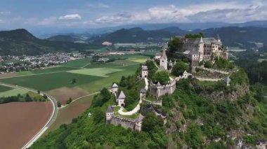 Tepedeki Hochosterwitz Kalesi 'ni, güçlendirilmiş duvarları, dramatik uçurumları, yaz renklerini, silip süpüren hava hareketlerini, tarihi dönüm noktalarını görüntüleyen sinematik dron görüntüleri.