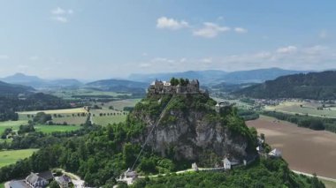 Tepedeki Hochosterwitz Kalesi 'ni, güçlendirilmiş duvarları, dramatik uçurumları, yaz renklerini, silip süpüren hava hareketlerini, tarihi dönüm noktalarını görüntüleyen sinematik dron görüntüleri.