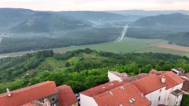 Yaz başında Hırvatistan 'ın İstriya tepesindeki Motovun ortaçağ kasabasının taş evler, yeşil vadiler, üzüm bağları ve otantik Avrupa mirası manzarasıyla çekilmiş sinematik insansız hava aracı görüntüleri