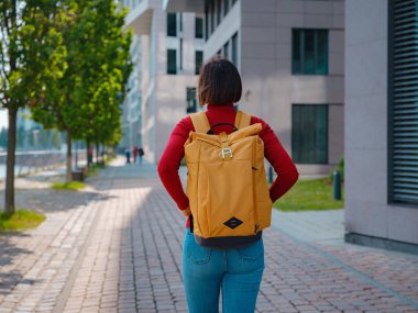 Turist kadın modern Frankfurt 'u keşfediyor, çağdaş mimari, gökdelenler ve kentsel alanlarla hareketli caddelerde yürüyor, modern yan tarafların canlı atmosferinin tadını çıkarıyor..