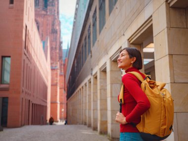 Turist kadın, tarihi caddelerini, güzel mimarisini ve kültürel yapısını keşfetmek için eski Frankfurt kasabasında geziniyor..