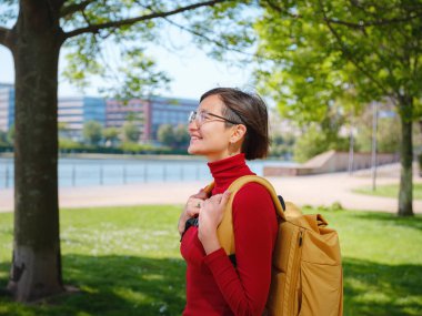 Turist kadın modern Frankfurt 'u keşfediyor, çağdaş mimari, gökdelenler ve kentsel alanlarla hareketli caddelerde yürüyor, modern yan tarafların canlı atmosferinin tadını çıkarıyor..