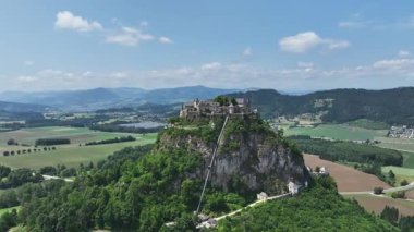 Tepedeki Hochosterwitz Kalesi 'ni, güçlendirilmiş duvarları, dramatik uçurumları, yaz renklerini, silip süpüren hava hareketlerini, tarihi dönüm noktalarını görüntüleyen sinematik dron görüntüleri.