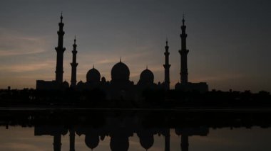 Abu Dabi 'deki Şeyh Zayed Camii' nin günbatımının çarpıcı manzarası. Büyük mimari, dingin atmosfer onu BAE 'deki İslam kültürünün ve ruhaniliğin dikkate değer bir sembolü yapıyor. Wahat Al Karama 'dan görüntü