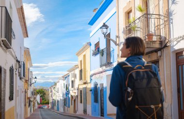 İspanya 'nın Alicante eyaletinin büyüleyici dar sokaklarında gezinen, tarihi Akdeniz mimarisi ile çevrili, barışçıl atmosfer ve kültürel ortamın tadını çıkaran genç bir kadın..