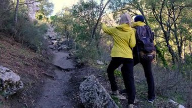 Genç bir çift, Türkiye 'nin huzurlu ormanlarında yürüyüş yapıyor. Sakin bir an, sıcak kıyafetler, manzaralı doğa ve doğal ortamda yakalanan seyahat aşkı..