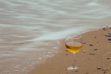 Romantik bir bardak şarap oturma plaj, bulutlu sonbahar hava, soğuk rüzgar