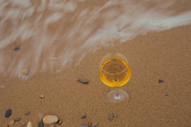Romantik bir bardak şarap oturma plaj, bulutlu sonbahar hava, soğuk rüzgar