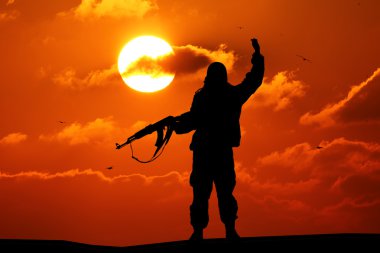 Silhouette of military soldier or officer with weapons at sunset. shot, holding gun, colorful sky, mountain, background clipart