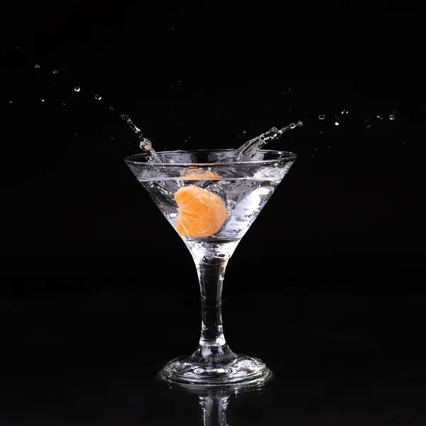 Martini-Cocktail spritzt in Glas auf schwarzem Hintergrund — Stockfoto
