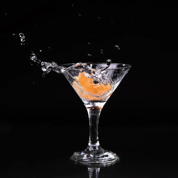 Cocktail martini spruzzi in vetro su sfondo nero — Foto Stock