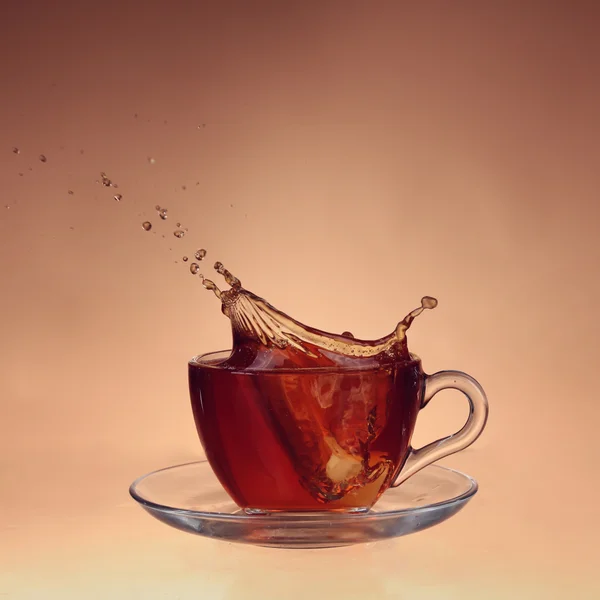 Taza de té sobre vidrio con fondo naranja — Foto de Stock