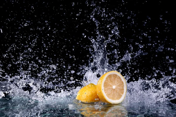 Zitronenscheiben im Wasser auf schwarzem Hintergrund — Stockfoto