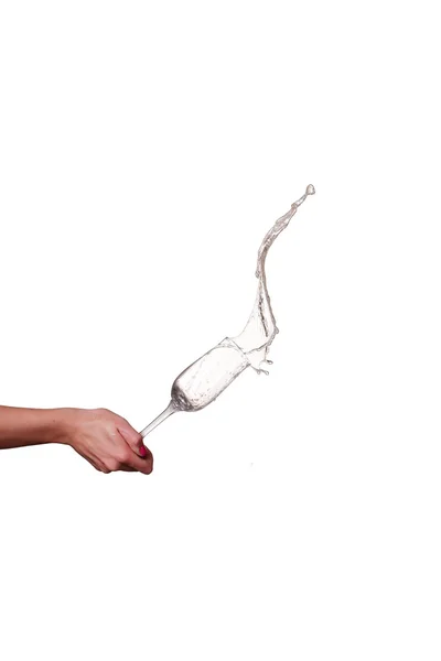 Брызги шампанского из стекла с женской рукой на белом фоне — стоковое фото