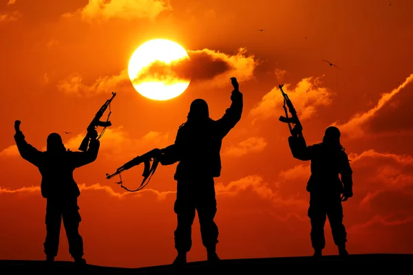 Silhouette eines Soldaten oder Offiziers mit Waffen bei Sonnenuntergang. Schuss, Gewehr halten, bunter Himmel, Berg, Hintergrund — Stockfoto